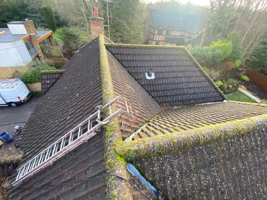 Professional roof cleaning in London, United Kingdom, removing moss, algae, and dirt from a tiled roof.