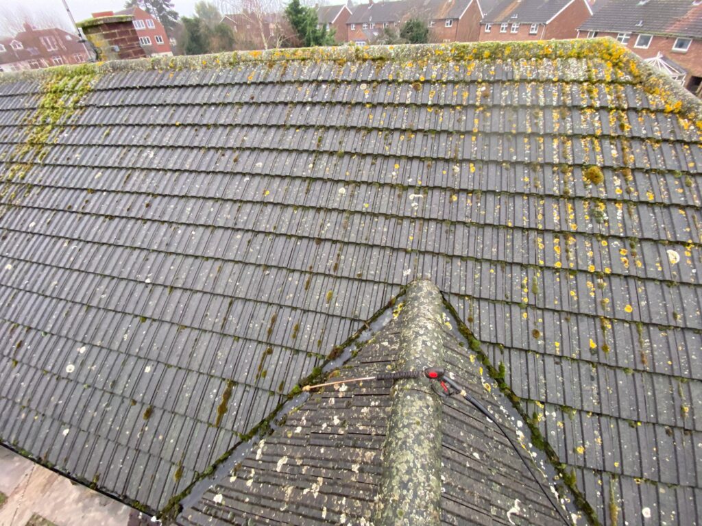 Professional roof cleaning in London, United Kingdom, removing moss, algae, and dirt from a tiled roof.